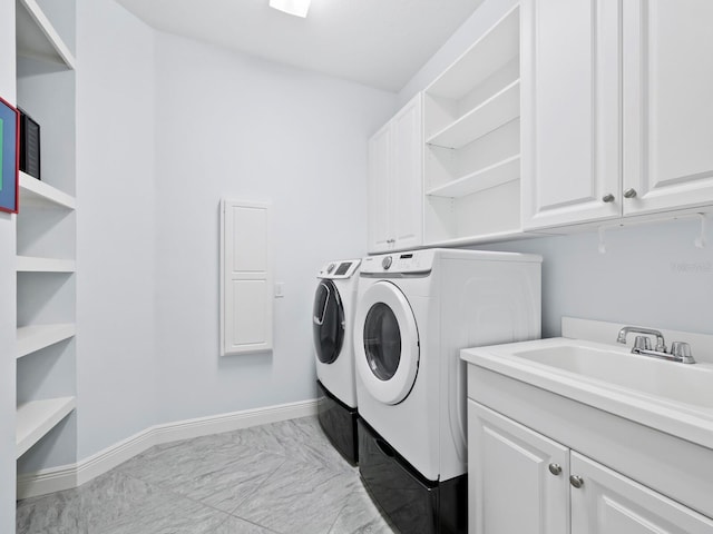 laundry area with cabinets, independent washer and dryer, and sink