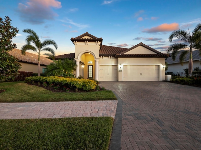 mediterranean / spanish house with a garage, a yard, and central AC