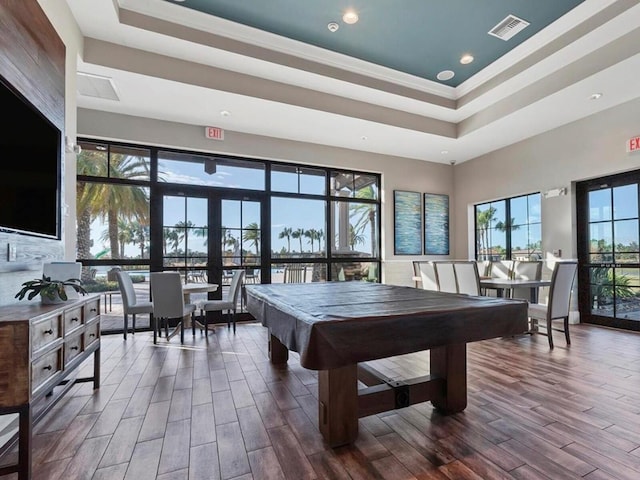 rec room featuring a raised ceiling, billiards, and hardwood / wood-style flooring