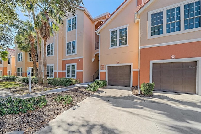 4106 Central Sarasota Pkwy Unit 1026, Sarasota, FL 34238 - view of property with an attached garage, driveway, and stucco siding