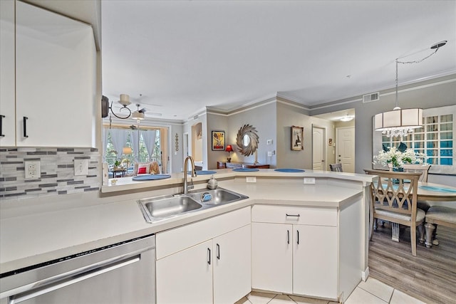 4106 Central Sarasota Pkwy Unit 1026, Sarasota, FL 34238 - kitchen featuring stainless steel dishwasher, a sink, light countertops, a chandelier, and ornamental molding