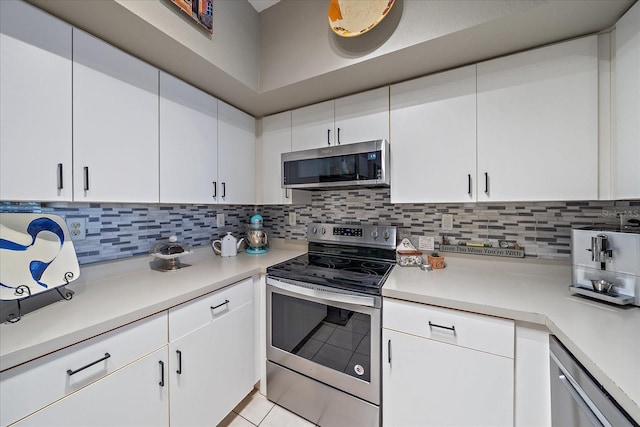 kitchen featuring decorative backsplash, white cabinets, light tile patterned flooring, and appliances with stainless steel finishes