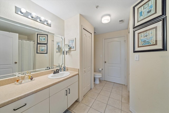 bathroom featuring tile patterned flooring, vanity, and toilet