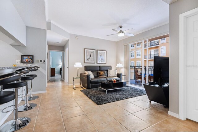 living room with ceiling fan, light tile patterned floors, and ornamental molding