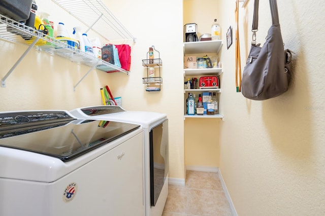 laundry room with washer and dryer and light tile patterned floors