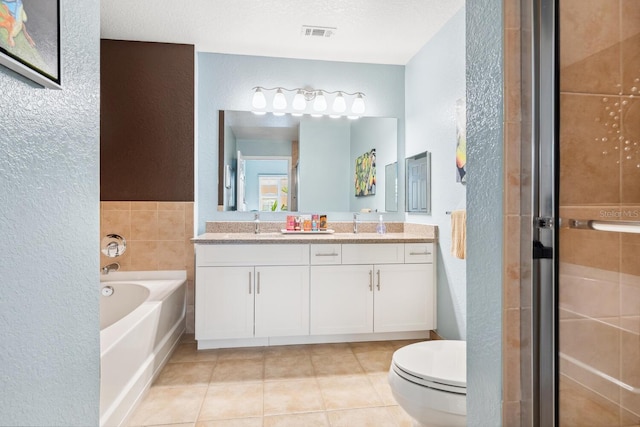 full bathroom featuring tile patterned floors, vanity, separate shower and tub, and a textured ceiling