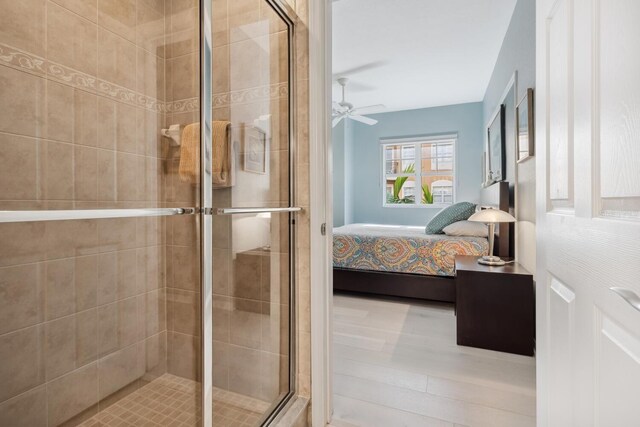 bathroom with ceiling fan and a shower with shower door