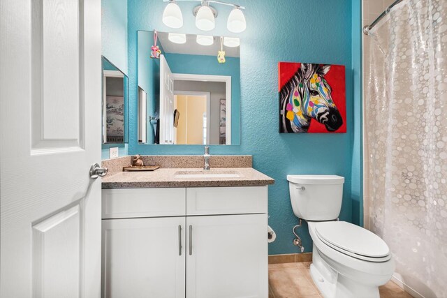 bathroom featuring walk in shower, tile patterned flooring, vanity, and toilet