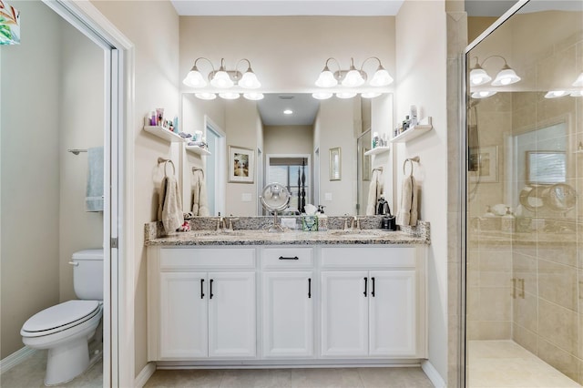 bathroom with tile patterned floors, vanity, toilet, and a shower with door