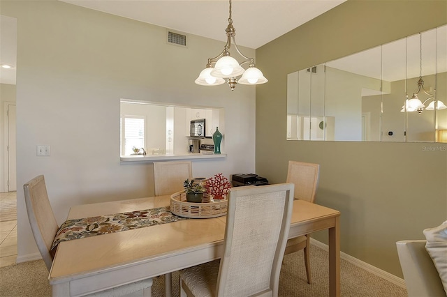 carpeted dining room featuring a chandelier