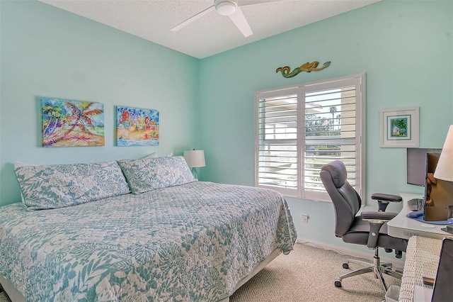 carpeted bedroom featuring ceiling fan and a textured ceiling