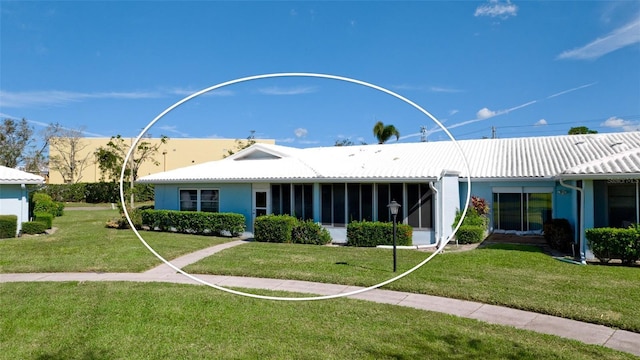 rear view of property featuring a lawn and a sunroom