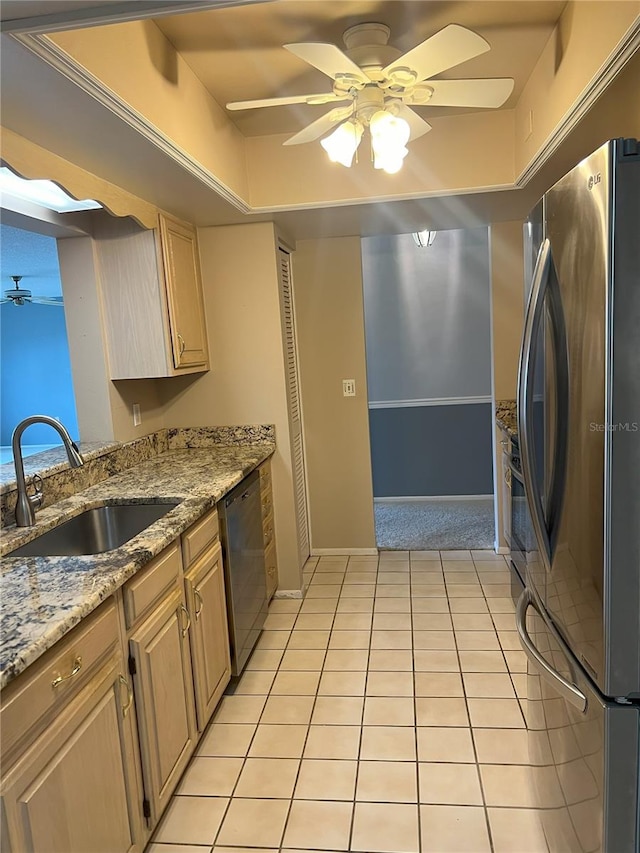 kitchen with sink, light tile patterned floors, appliances with stainless steel finishes, light stone countertops, and light brown cabinetry