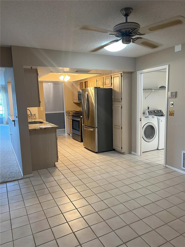 kitchen featuring light tile patterned floors, a textured ceiling, and appliances with stainless steel finishes