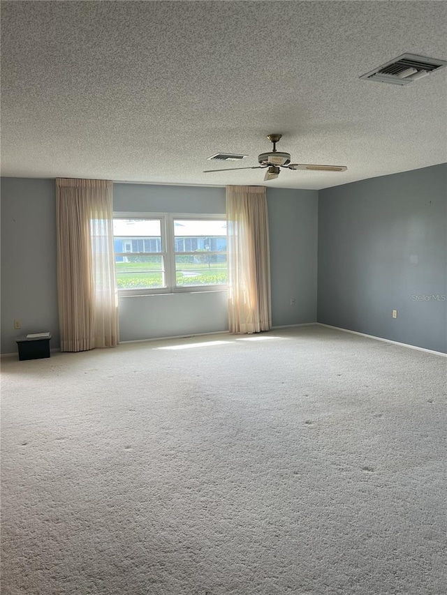 carpeted spare room featuring a textured ceiling and ceiling fan