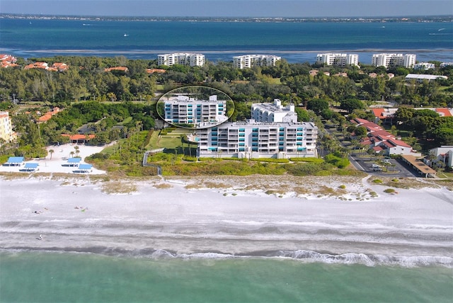 birds eye view of property featuring a water view and a beach view