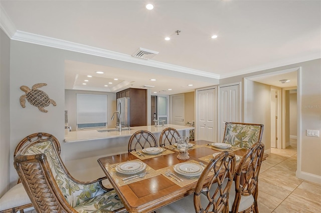 dining space with light tile patterned floors, crown molding, and sink