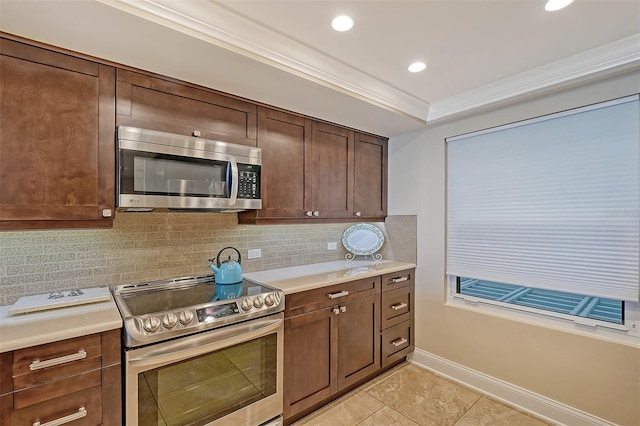 kitchen with light tile patterned floors, ornamental molding, appliances with stainless steel finishes, tasteful backsplash, and dark brown cabinets