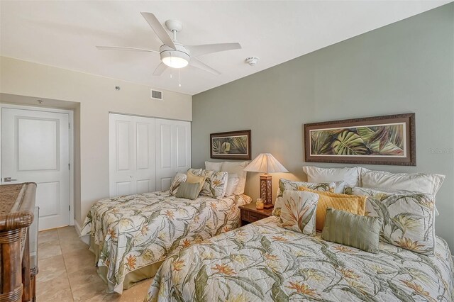 bedroom with ceiling fan, a closet, and light tile patterned floors