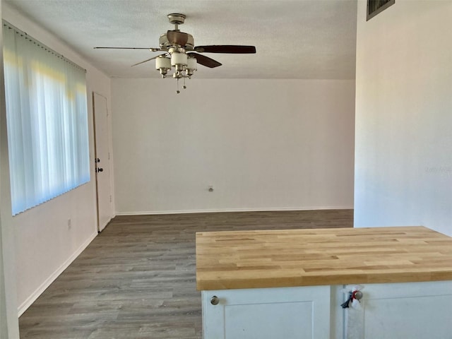 empty room with hardwood / wood-style floors, ceiling fan, and a textured ceiling