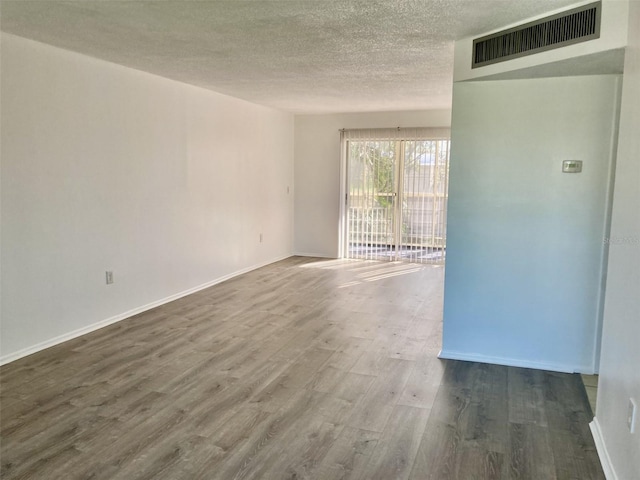 4480 Ironwood Cir Unit 218A, Bradenton, FL 34209 - spare room featuring wood finished floors, a textured ceiling, and baseboards