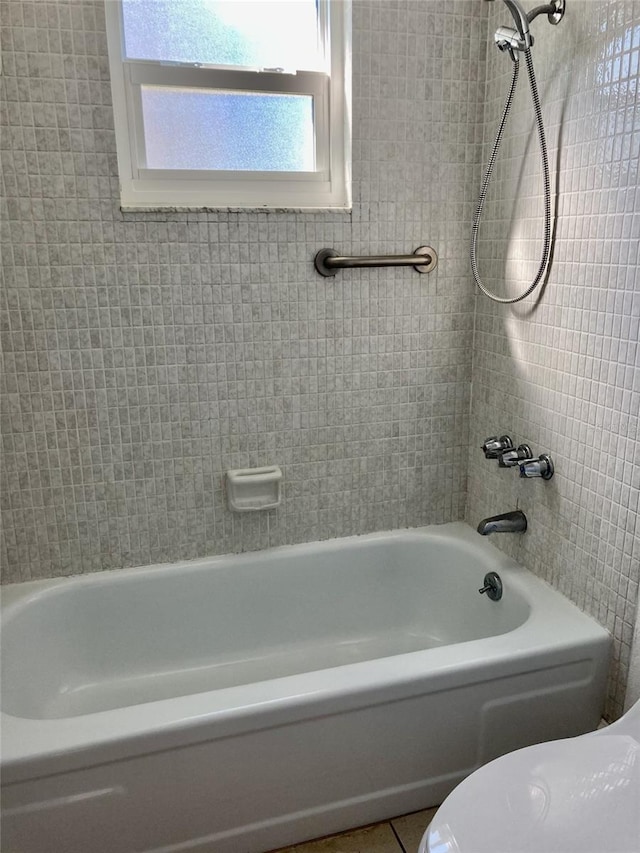 bathroom featuring tile patterned flooring and tiled shower / bath