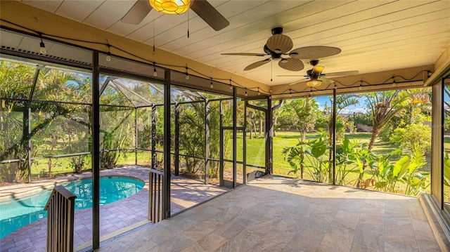 unfurnished sunroom featuring ceiling fan, wooden ceiling, and a pool