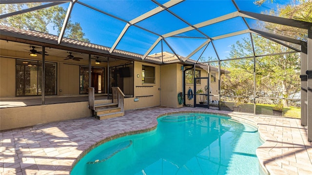 view of swimming pool featuring ceiling fan, a patio, and glass enclosure