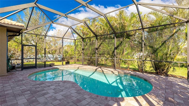 view of pool featuring glass enclosure and a patio area