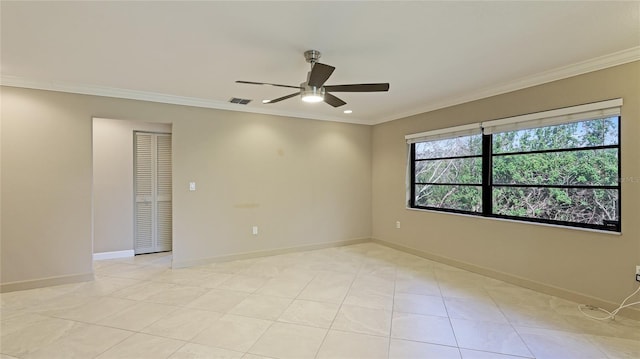 tiled empty room featuring ceiling fan and crown molding