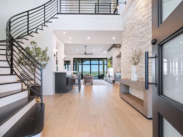 entrance foyer featuring a high ceiling, light wood-type flooring, and ceiling fan