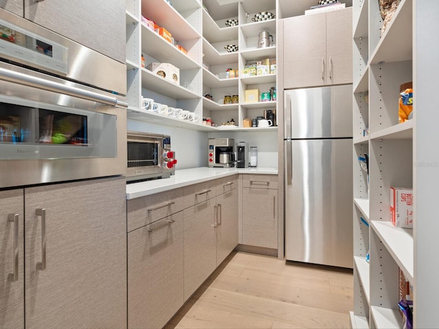 kitchen with stainless steel refrigerator and light hardwood / wood-style flooring