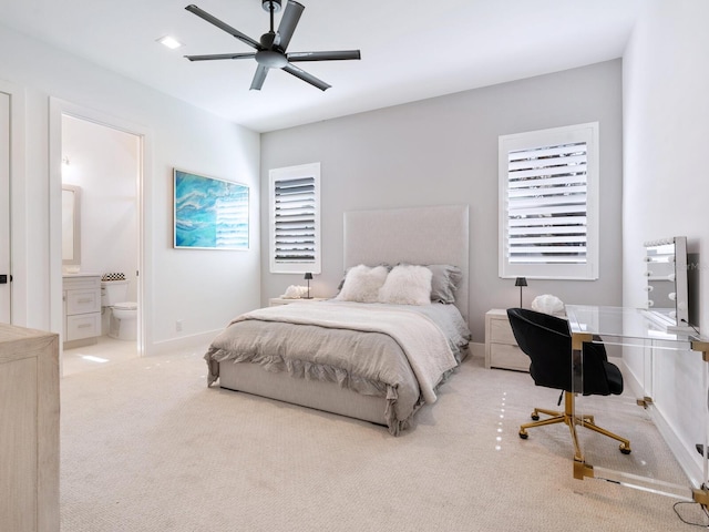 bedroom with ensuite bathroom, ceiling fan, and light colored carpet