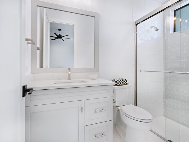 bathroom with ceiling fan, vanity, a shower with shower door, and toilet