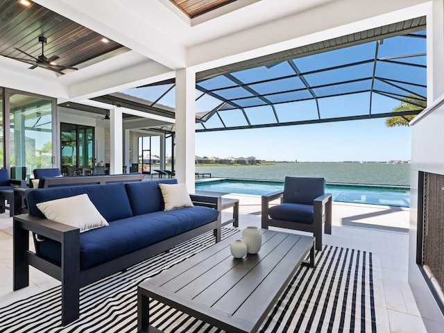 view of patio featuring a lanai, ceiling fan, a water view, and an outdoor hangout area