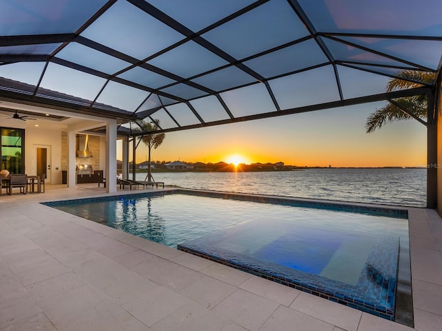 pool at dusk featuring a water view, a patio area, ceiling fan, and a lanai