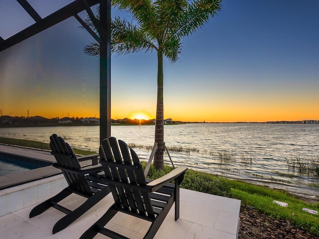 patio terrace at dusk featuring a water view