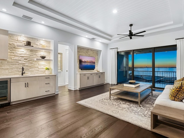 living room with a tray ceiling, wine cooler, ceiling fan, and wood ceiling