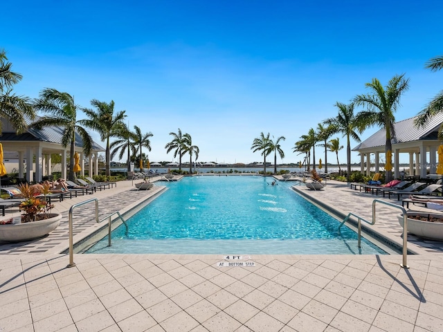 view of swimming pool with pool water feature and a patio area