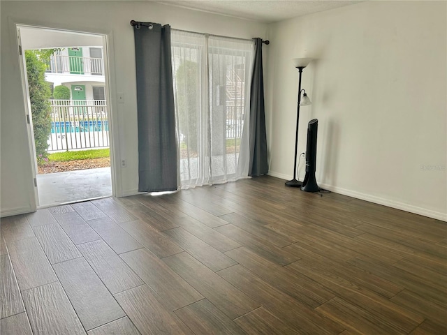 unfurnished living room with baseboards and wood finish floors