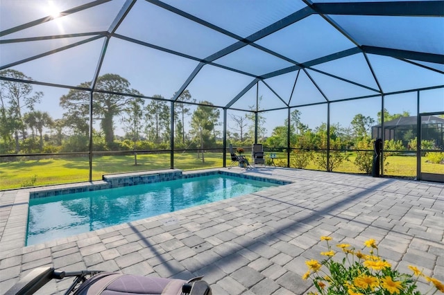 view of swimming pool featuring a yard, a patio area, and a lanai