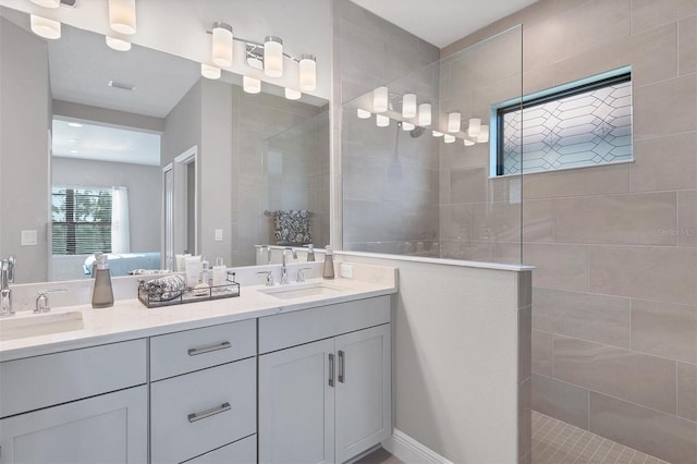 bathroom with vanity and a tile shower