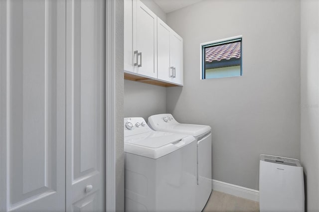 laundry area with washer and clothes dryer and cabinets