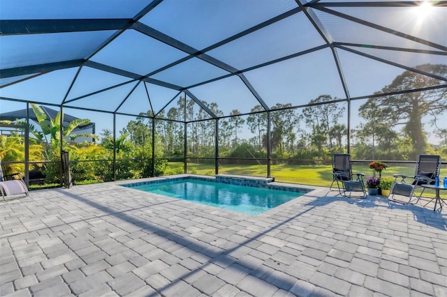 view of pool with glass enclosure and a patio area