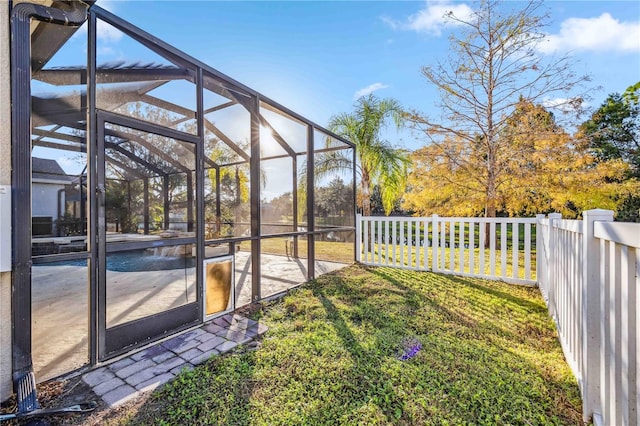 view of yard featuring glass enclosure, a patio, and a pool