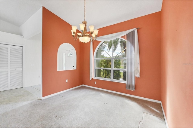 empty room with light carpet, an inviting chandelier, and vaulted ceiling