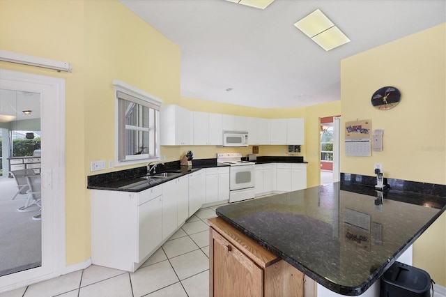 kitchen featuring white cabinetry, sink, kitchen peninsula, white appliances, and light tile patterned floors