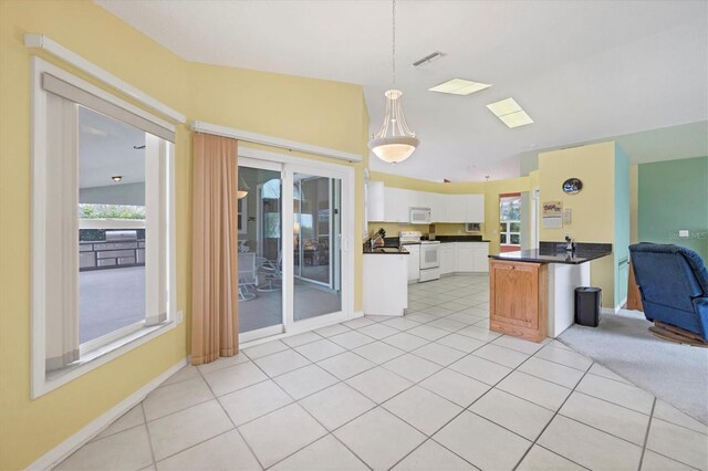 kitchen featuring hanging light fixtures, white cabinets, lofted ceiling, white appliances, and light tile patterned flooring