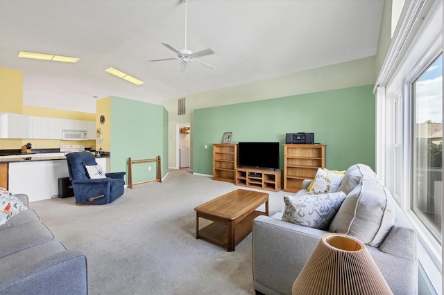 living room with ceiling fan, light carpet, and lofted ceiling