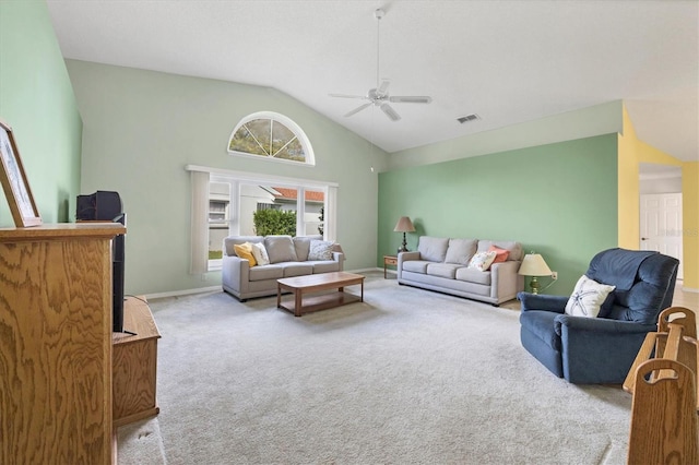 carpeted living room with ceiling fan and high vaulted ceiling